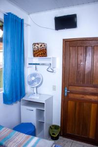 a room with a door and a fan on a desk at Pousada Bela Vista in Castro