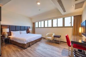 a hotel room with a bed and a television at Jih Lih Hotel in Magong