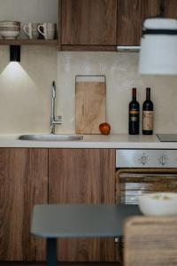 a kitchen with a sink and bottles of wine at Antigone's Stone House in Plakias