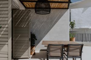 a patio with a wooden table and chairs at Antigone's Stone House in Plakias