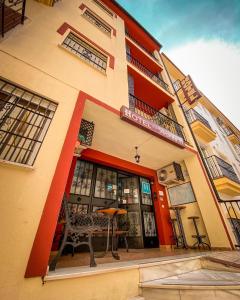 un edificio con un banco delante de él en Hotel Arunda II en Ronda