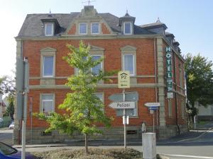 un bâtiment en briques rouges avec un panneau de rue devant lui dans l'établissement Hotel Kitzinger Hof an der B8, à Kitzingen