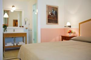 a bedroom with a bed and a bathroom with a sink at Piazza Di Spagna Prestige in Rome