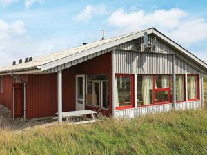 a red and white house on top of a hill at 10 person holiday home in Harbo re in Harboør