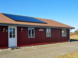 a red building with solar panels on the roof at 10 person holiday home in Harbo re in Harboør