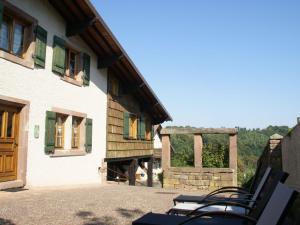 a group of chairs sitting outside of a building at Authentic chalet with terrace in Harreberg in Hommert