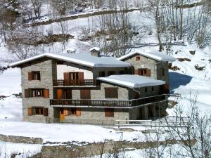 a house with snow on top of it in the snow at Magnificent chalet with sauna in Le Villard