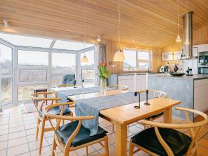 a kitchen and dining room with a table and chairs at Five-Bedroom Holiday home in Hjørring 2 in Lønstrup