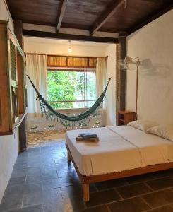 a bedroom with a hammock in a room at Pousada Bodega da Terra in Pirangi do Norte