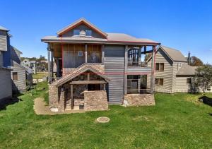 a house with a stone grill in the yard at Triggerplant 4 in Dinner Plain