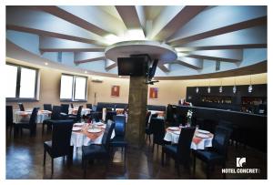 a dining room with tables and chairs and a tv at Hotel Concrete in Ungheni