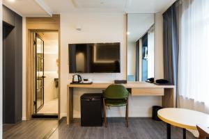 a hotel room with a desk and a television at Casaloma Hotel in Seogwipo