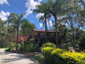 una casa con palmeras frente a una carretera en B&B Home in the Country, en Barellan Point