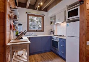 a kitchen with blue and white appliances and a window at Montane in Dinner Plain