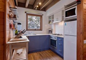 una cocina con electrodomésticos azules y blancos y una ventana en Montane, en Dinner Plain
