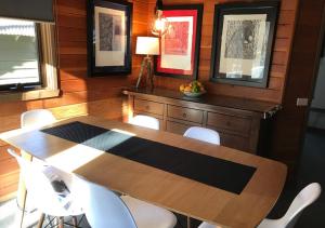 Un comedor con una mesa de madera y sillas blancas. en Montane, en Dinner Plain 7 fotos más