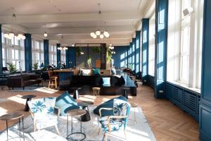 a lobby with blue walls and tables and chairs at PHNX Aparthotel Hamburg in Hamburg