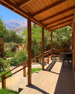 a wooden pergola with a table and chairs on a deck at Hotel El Tesoro de Elqui in Pisco Elqui