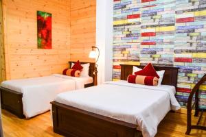 two beds in a room with a colorful wall at Little England Bungalow in Nuwara Eliya