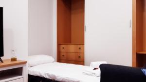 een kleine kamer met 2 bedden en een bureau bij VUT San Cristóbal LARANITASALAMANTINA in Salamanca