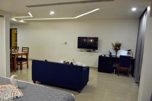 a living room with a couch and a flat screen tv at Hotel Sree Annamalaiyar Park in Tirunelveli