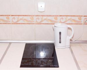a stove in a kitchen with a mug on the floor at Aleksapart in Burgas City