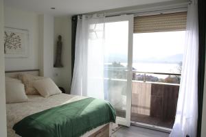 a bedroom with a bed and a large sliding glass door at Precioso apartamento con magníficas vistas - Apartamento Aifos in Santander