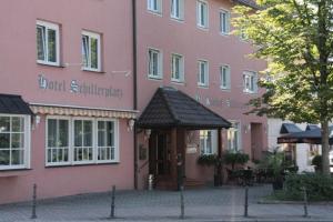 厄赫林根的住宿－席勒鋪拉茨酒店，前面有遮篷的粉红色建筑