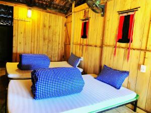 um quarto com 2 camas numa parede de madeira em Mun Homestay em Ha Giang