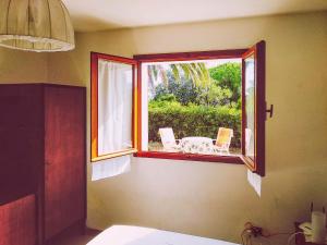 a window in a room with a table and chairs at Villino Kalithea in Cavo