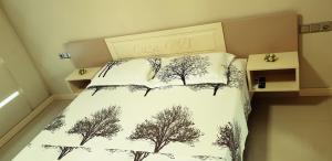 a bed with two pillows with trees on it at Casa Ovi in Saturn