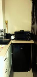 a kitchen with a black microwave and a dishwasher at Casa Ovi in Saturn