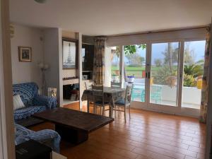 a living room with a couch and a table and a dining room at Carrer Voramar 11 in L'Eucaliptus