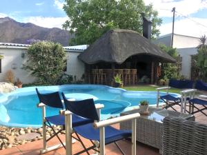 a swimming pool with chairs and a gazebo at John Montagu Accommodation in Montagu