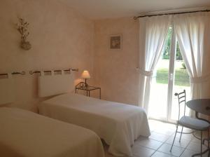 A bed or beds in a room at Le Clos des Cigales