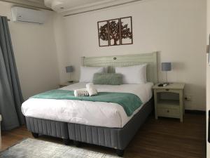 1 dormitorio con 1 cama grande y 2 toallas. en Omaha Luxury B&B/Spa, en Mthatha