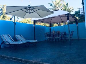 a group of chairs and umbrellas on a patio at Omaha Luxury B&B/Spa in Mthatha