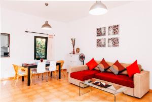 sala de estar con sofá rojo y mesa en Casa Higuereta I, en Corralejo