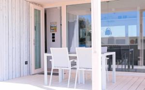 einen weißen Esstisch und weiße Stühle auf der Veranda in der Unterkunft Camp Buqez 45 - Villa Artica in Pakoštane