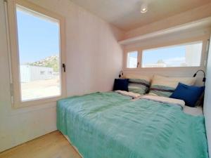ein Schlafzimmer mit einem Bett und zwei Fenstern in der Unterkunft Camp Buqez 45 - Villa Artica in Pakoštane