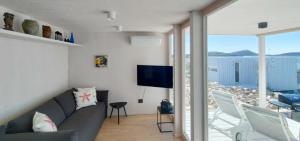 ein Wohnzimmer mit Couch und Fernseher in der Unterkunft Camp Buqez 45 - Villa Artica in Pakoštane