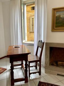 una mesa de madera y una silla en una habitación con chimenea en Fontana di San Giacomo, en Bérgamo