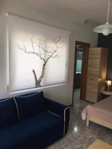 イエリソスにあるKoala Apartments- Irida, Elea Ierissosのリビングルーム(青いソファ、木の壁付)