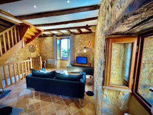 un soggiorno con un divano e una TV di Cottage du Capiol en Périgord a Cénac-et-Saint-Julien
