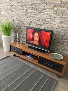 a flat screen tv sitting on top of a wooden entertainment center at SOLE Apartment 1 in Satu Mare