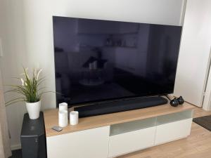 a large flat screen tv sitting on top of a cabinet at The River 31, Baritoni in Pori