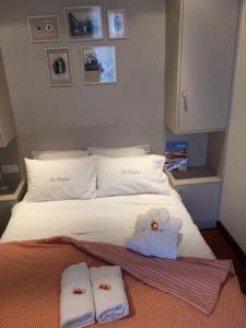 ein Schlafzimmer mit einem Bett, auf dem zwei Handtücher liegen in der Unterkunft Les Bruyères in Les Sables-dʼOlonne