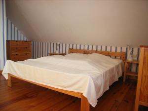 1 dormitorio con 1 cama con sábanas blancas y suelo de madera en REF 034 Maison deux chambres pour cinq personnes proche Golfe du Morbihan LE MONTENO ARZON en Arzon
