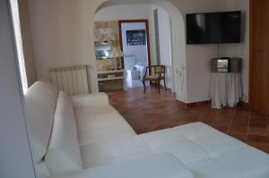 a living room with a white couch and a television at Il Sogno Caltagirone in Caltagirone