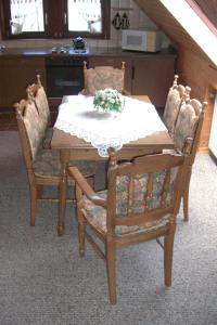 - une table à manger, des chaises, une table et des fleurs dans l'établissement Apartment Central, à Willingen